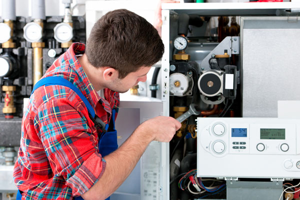HVAC technician inspecting and repairing boiler controls in Fountain Hills