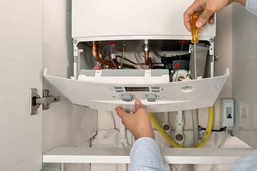 HVAC technician repairing an indoor boiler in Fountain Hills