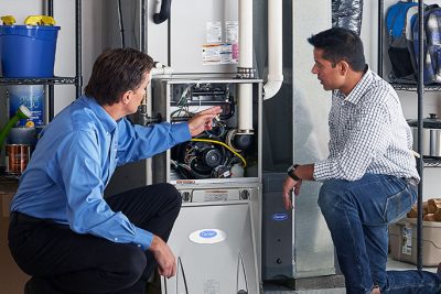 65df8c11f3e4c468cbd351a5_furnace repair vs replacement – Copy HVAC technician explaining furnace repair and maintenance to a homeowner in Fountain Hills, AZ