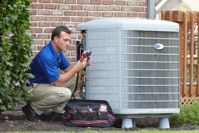design-air-heating-and-air-conditioning-decatur-il-05 – Copy HVAC technician inspecting an outdoor air conditioning unit in Fountain Hills, AZ